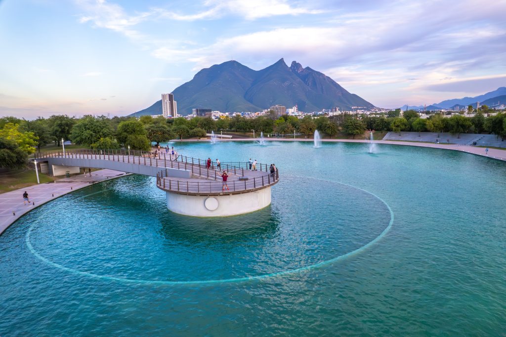 Vista aÃ©rea de la laguna del Paseo Santa LucÃ­a con fuentes y el Cerro de la Silla al fondo.